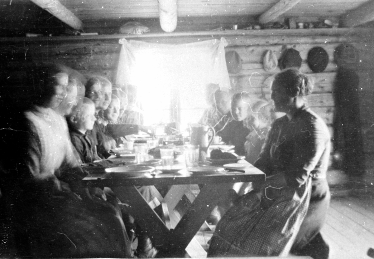 Anno Domkirkeodden, Interiør, størhuset på Øyungen seter, Ringsaker fjellt. Familien Løken fra Granerud gård, Brumunddal samlet til måltid ved bordet.