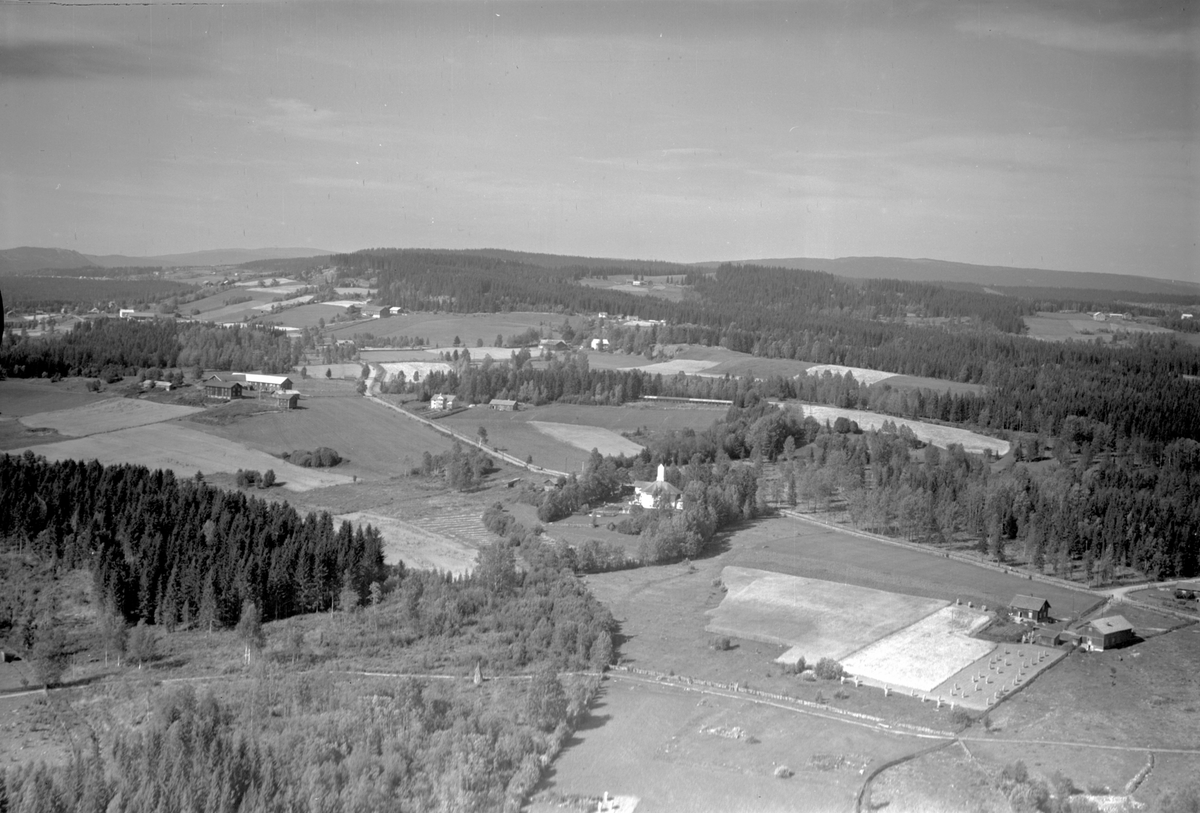 Anno Domkirkeodden, Flyfoto, Åsmarka kapell, landskap. Lengst til venstre Nedre Åsen med kårbolig vis a vis over veien. Til høyre foran: Kirkenær.
