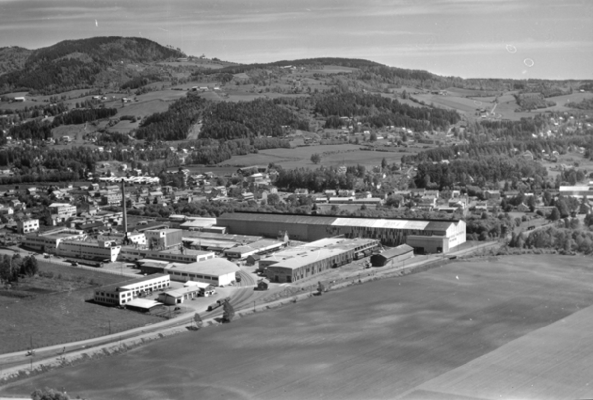 Widerøes Flyveselskap A/S, Flyfoto av Brumunddal med Berger Langmoen AS i forgrunn og Høsbjøråasen i bakgrunn.