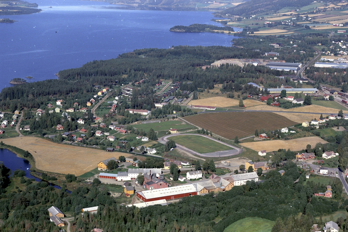 Widerøes Flyveselskap A/S, Flyfoto, Strand brenneri i forgrunnen, bebyggelsen ved idrettsparken, Mjøsa og Ring, Moelv, Ringsaker.