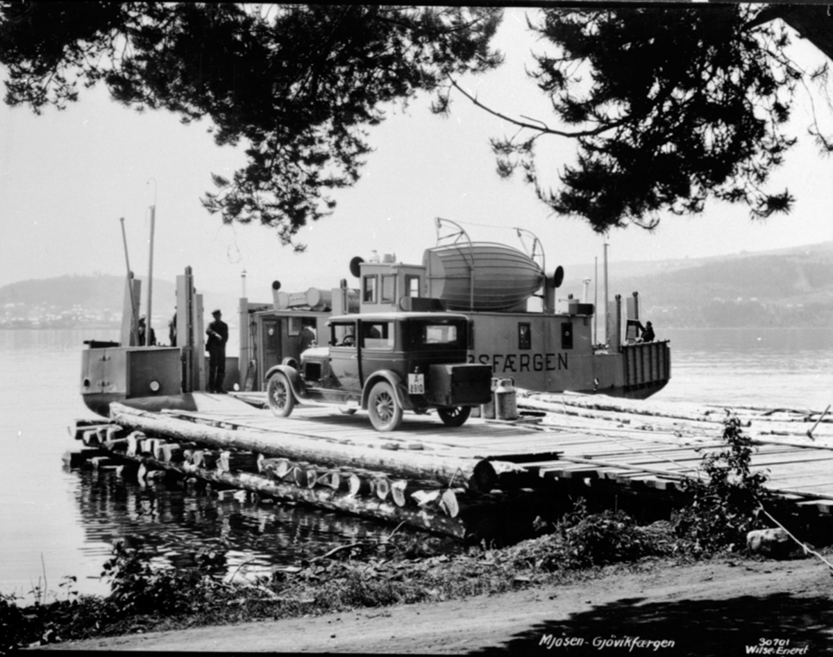 Anno Domkirkeodden, Mjøsfergen for passasjer og biltransport ved den gamle brygga ved Mengshol fergested, Nes, Hedmark. Bil med nummer A-8910 i ferd med å kjøre ombord. Antagelig fotograf Wilse sin bil.