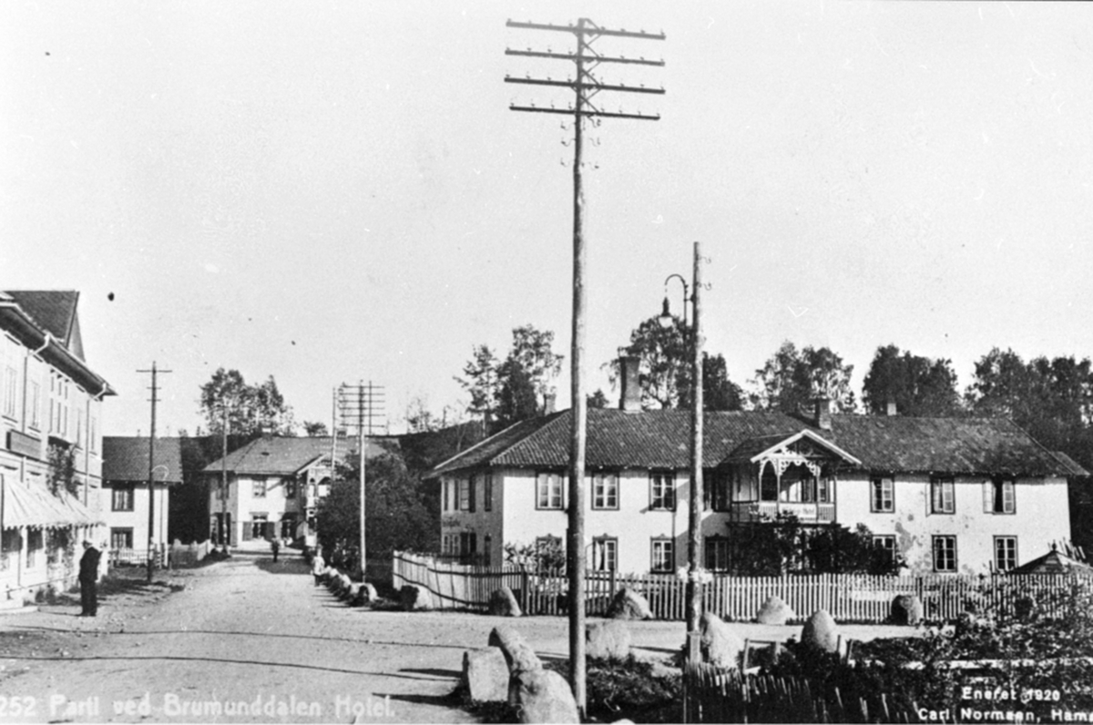 Anno Domkirkeodden, Furnesvegen, Industrigata, Fra venstre er Kooperativen, Stampen, Heimdal. Til høyre er Brumunddal Hotell. Postkortorginaler: Sjur Dagestad, Brumunddal.