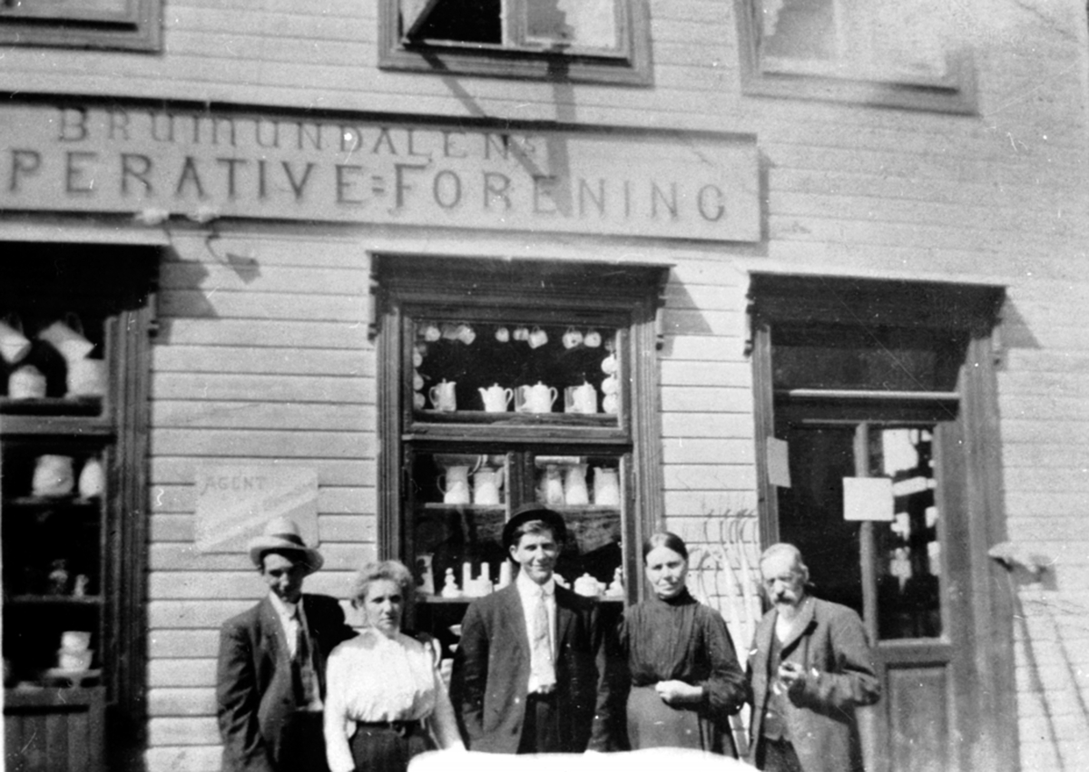 Anno Domkirkeodden, Heimdal nedre, Brumunddalens Kooperative Forening. Til høyre er Ingeborg, Mikael Andersen. Gamlegata, Brumunddal. Her holdt den første kooperativen til fram til 1919.