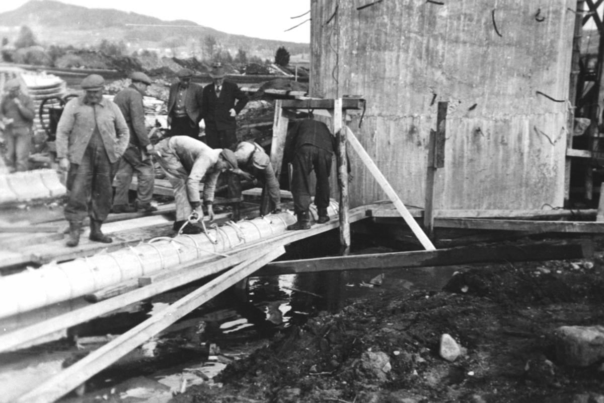 Anno Domkirkeodden, Bygging av vanninntak, pumpestasjon, vanninntaksledningen legges på plass, Hedmark Tørrmelk, Tine, Brumunddal. menn arbeider.