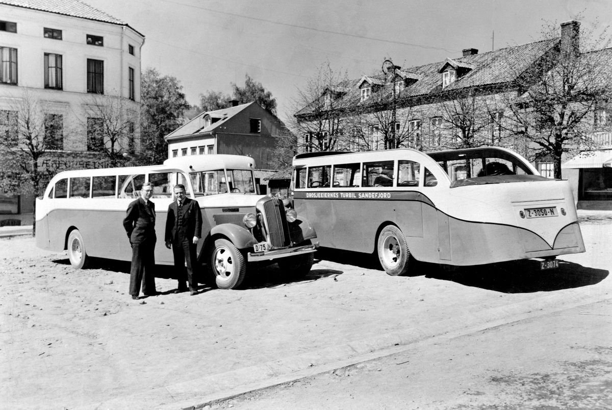 Anno Domkirkeodden, Kabriolet turbusser, karosseri bygd over Dodge chassis ved Hymas A/S, Brumunddal Mekaniske Verksted og støperi, fotografert på Stortorget i Hamar. Begge er Dodge årsmodell 1938, levert av Olrud Auto til drosjeeierforeningene i henholdsvis Hamar (til venstre med reg.nr D-75, 30 seter) og Sandfjord (…