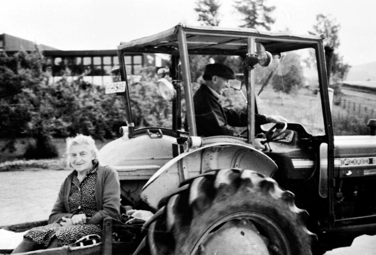 Anno Domkirkeodden, Johannes Nordhagen kjører en Ford traktor ved Veldre Samvirkelag, Ringsaker. Louise Nordhagen i transportkassen.