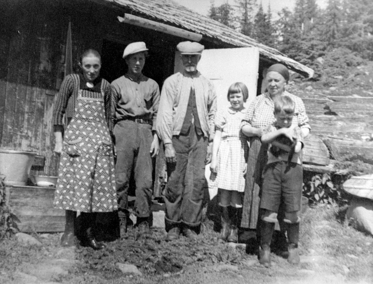 Anno Domkirkeodden, Gruppe foran størhus på Bonkerud seter, Ringsakerfjellet. Fra venstre er Agnethe Berglund, gjeter Olsen, sveiser Olaf Berglund, Agnethe Berglund, Inger Tangen, Julie Tangen, Ole Tangen.
