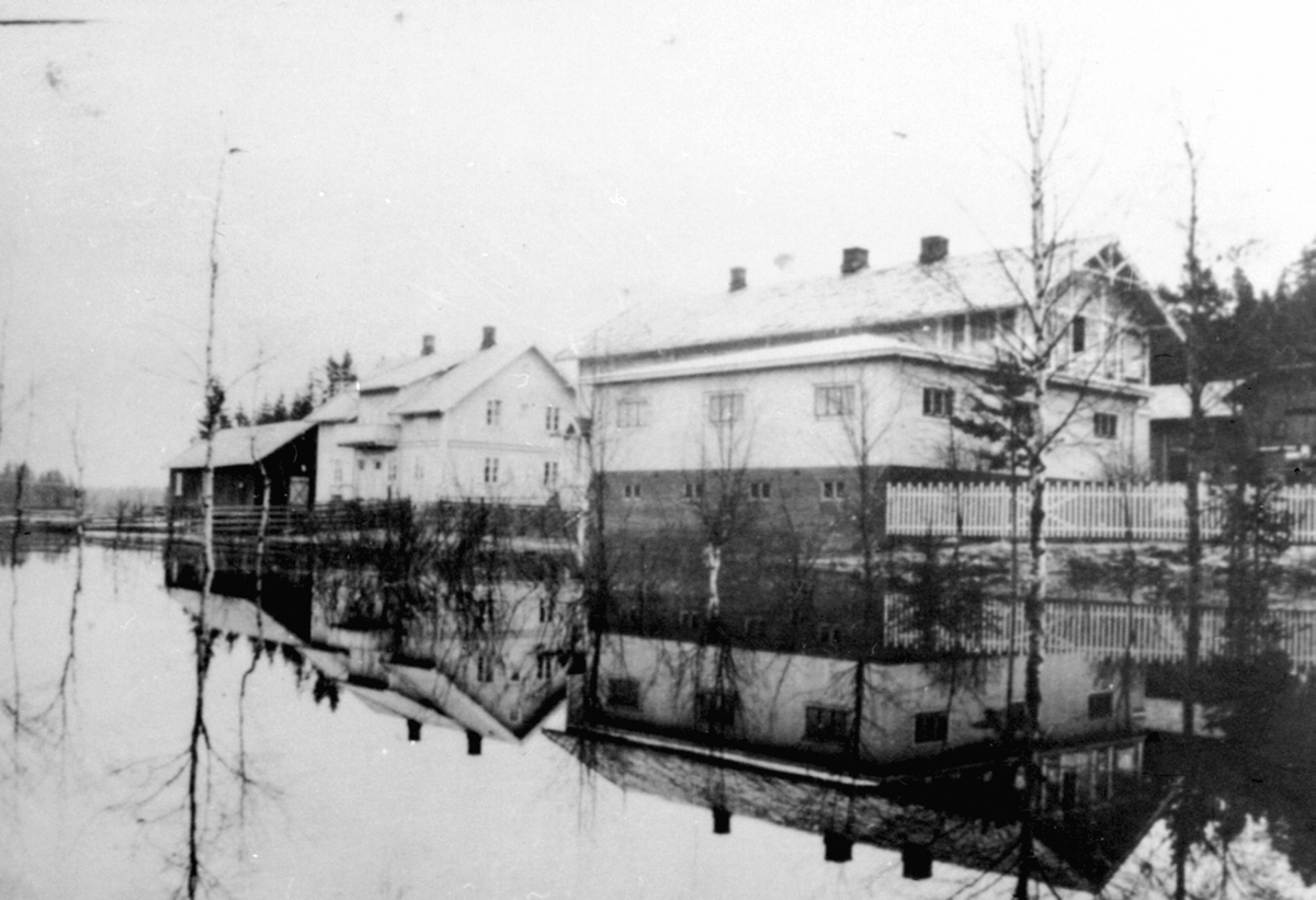 Anno Domkirkeodden, Eksteriør. Handelstedet Fagernes. Harby Landhandleri, Næroset, Ringsaker. Vårflom i 1938. Ny kafebygning med hybel for handelsbetjent og til overnatting for hestekjørere oppført i 1934. Butikken til høyre.