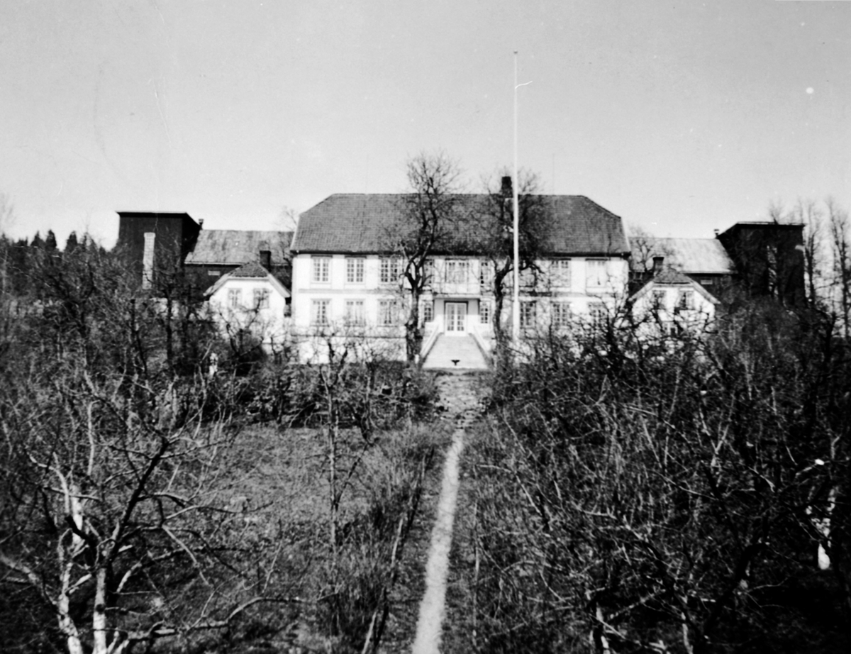 Anno Domkirkeodden, Hovedbygningen på Hovelsrud, Helgøya sett fra hagen. Den nye låven i bakgrunn.