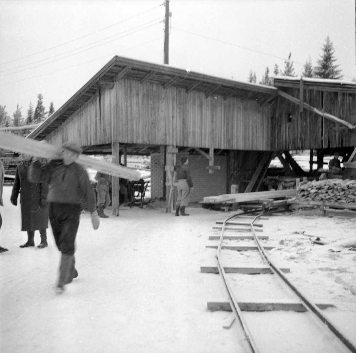 Anno Domkirkeodden, Sagbruk, mann bærer plank, skinnegang med vogner, Berger LAngmoen A/S, Brumunddal.