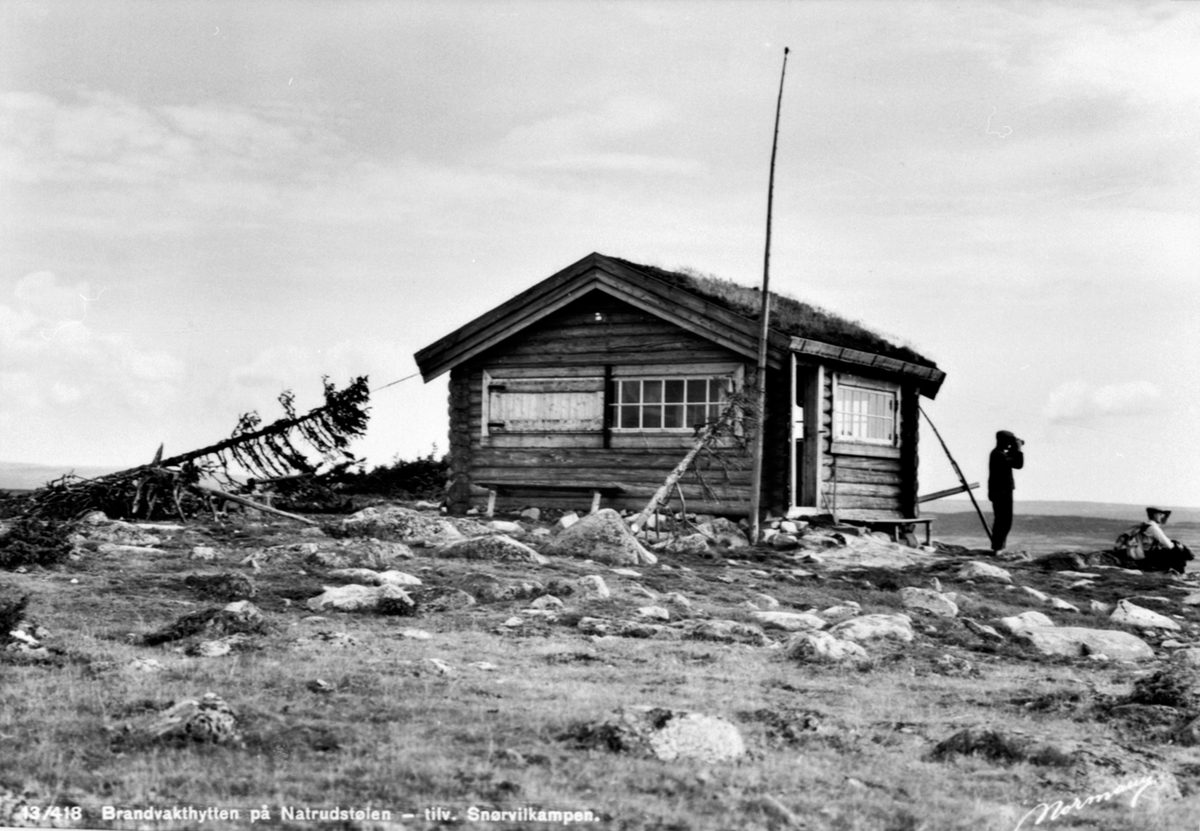 Anno Domkirkeodden, Brannvakthytta på Natrudstilen, Ringsaker Almenning. Brannvakt Olaf Bekkelund med kikkert. Ble ombygget i 1951-52. Hadde telefonforbindelse m/Brumundkampen og Knutberget i Stange. Hedmarksallmenningen eide alle vaktstasjonene.
