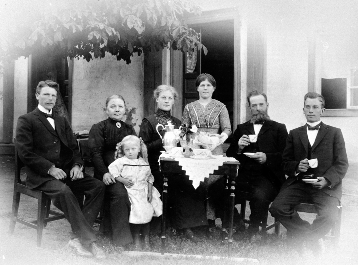 Anno Domkirkeodden, Kaffekos under kastanjetreet i hagen på Vien, Helgøya. Fra venstre er Jens Olausen Narmo (1861-1950), Marie Eriksdatter Narmo (1862-1932), Johanne Narmo f.1910, Anne Dorthea Narmo f.1893, Olga Narmo f.1896, Olaus Jensen Narmo (1861-1950), Erik Olausen Narmo (1891-1975).