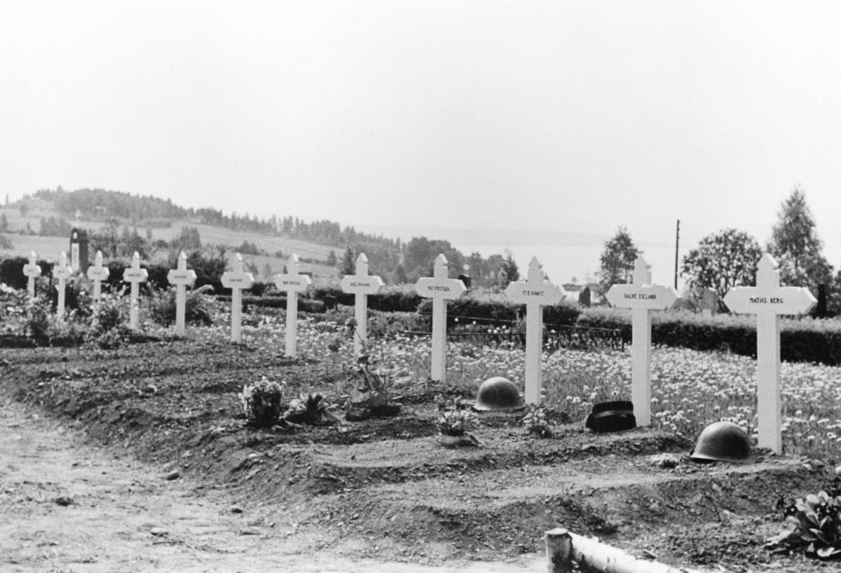 Anno Domkirkeodden, Gravsteder for falne ved kampene i Ringsaker i aprildagen 1940 på Ringsaker kirkegård. Hjelmer og kors.