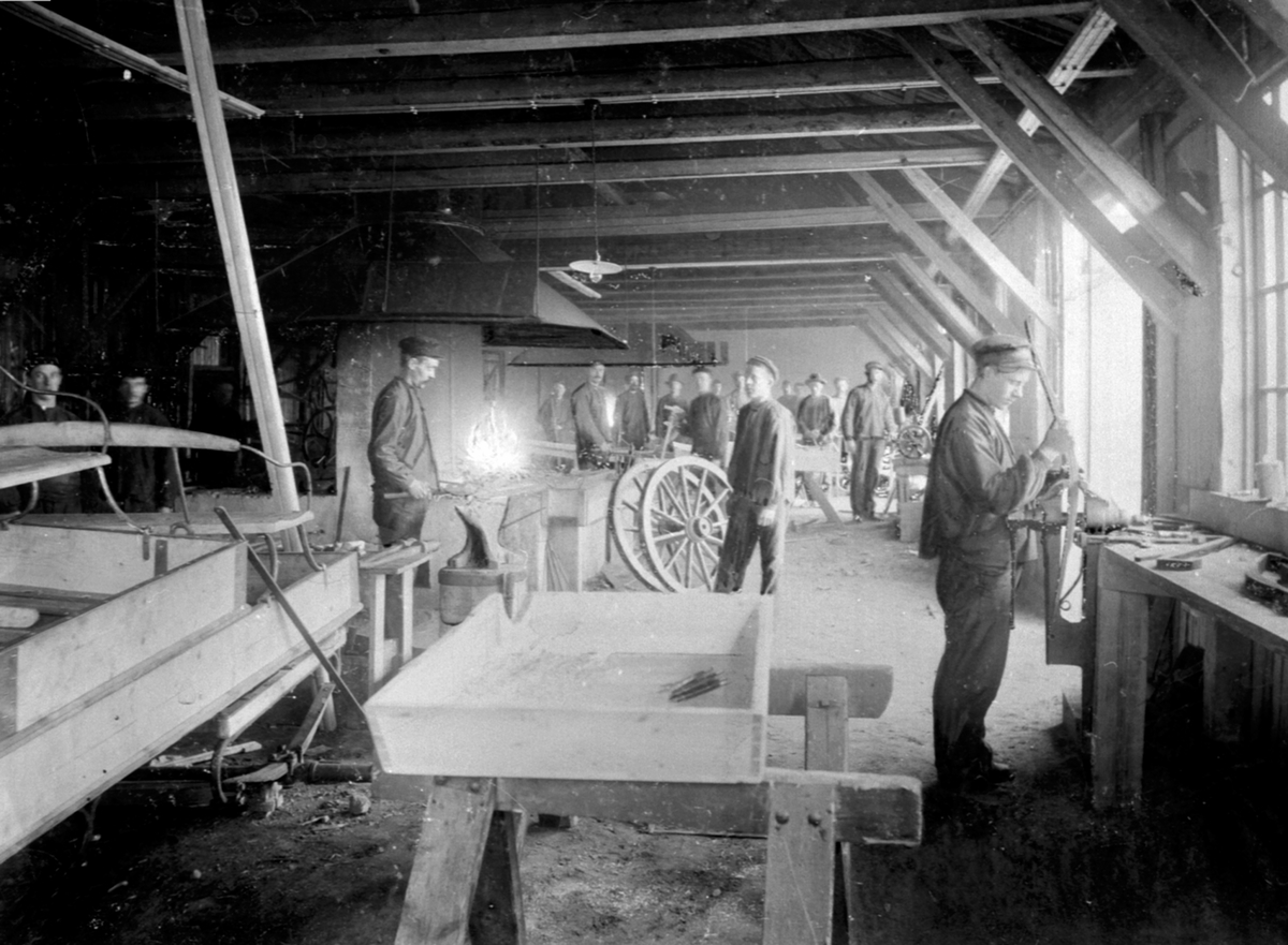 Anno Domkirkeodden, Interiør, smia på Moelven Brug. 18 mann i arbeid med produksjon av kjerrehjul. Smed.