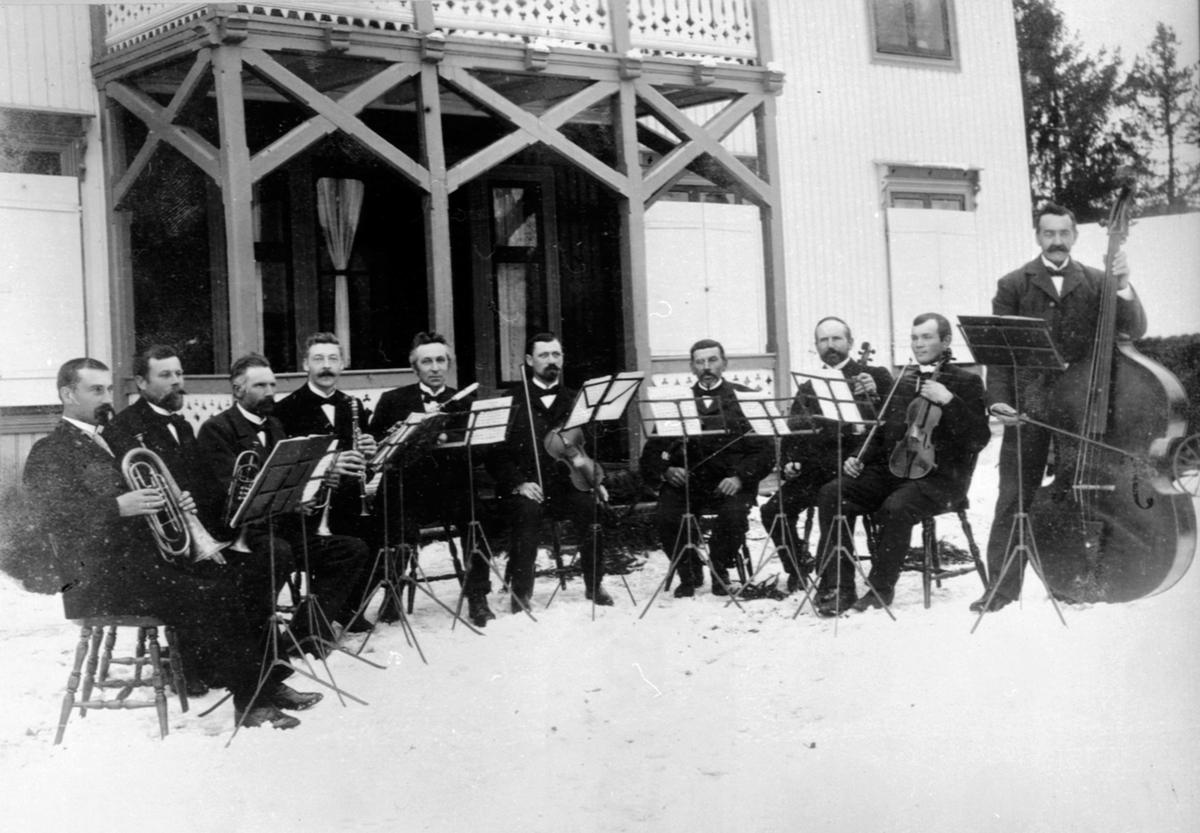 Anno Domkirkeodden, Gruppe musikere med instrumenter. Strykere og blåsere. Gaupen Musikkforening utenfor Dal, Gaupen. Fra venstre er Anton N. Huse, Johan Dompidal, Schjerpen, Ingvald Dompidal, Amundsen, Meieribestyrer Foss, Sendstad, Solberg, Schjønsbye, Baker Stransberg.
