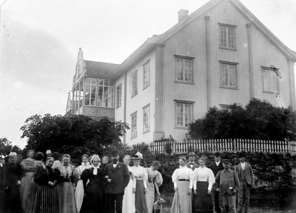 Anno Domkirkeodden, Stor gruppe mennesker utenfor hovedbygningen på Hoel gård, Nes, Hedmark. Gardbruker Karl Kildal (1854-1915) med skalk, moren Marie Gotaas Kildal til venstre (1817-1900).