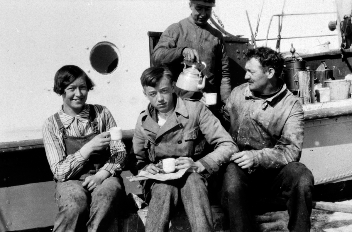 Anno Domkirkeodden, Kaffepause på Nes brygge foran Mjøsbåten "Kvikk". Maskinist Teodor Markeng skjenker kaffe. Foran fra venstre styrmann Gudrun Trogstad, dekksgutt Haakon Trogstad og deres far, kaptein Albert Trogstad, Nes, Hedmark.