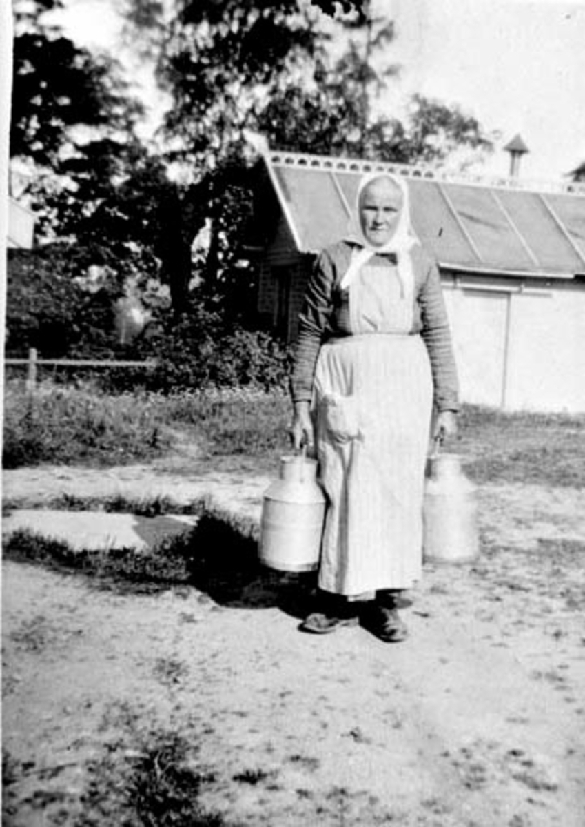 Anno Domkirkeodden, Fru Johansen med melkespann på husmannsplassen Møllerstuen, Nederkvern, Brumunddal.