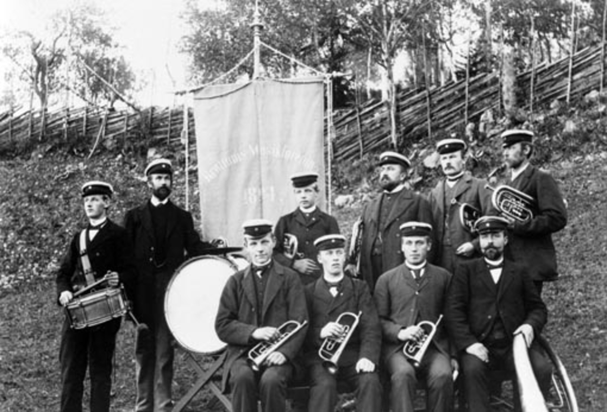 Anno Domkirkeodden, 10 menn med instrumenter og fane. Brøttum musikkforening stiftet 1894. Sittende fra venstre er Gudbrand O. Berg, Andreas Olsen, Even J. Bergseng, Even Graaten, Gulbrand P. Solberg. Stående fra venstre er Alfred H. Strandsveen, Johs R. Skrukkerud, Even O. Berg, Nils Solbakken, Syver J. Gaden, Erik N…