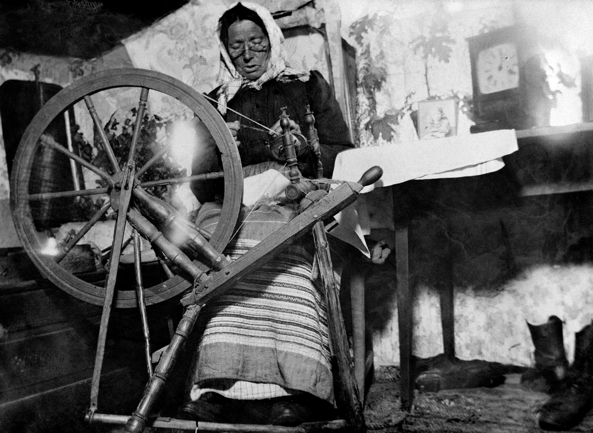Anno Domkirkeodden, Husmannskone ved rokken, spinner ull, på Grefsheim, Nes, Hedmark.
