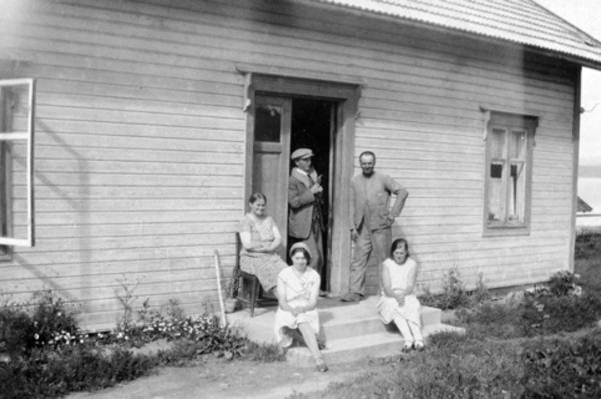 Anno Domkirkeodden, Ferjeekspedisjon og Helgøya Telefonselskap i Sundgård, Helgøya. På stolen sitter bestyrerinne ved Helgøen telefonsentral Helga Sund (1891-1962), til høyre er hennes mann bryggeekspeditør Karl Sund (1890-1962), de andre er Petter Røste f.1887, Ella og Emma Røste.