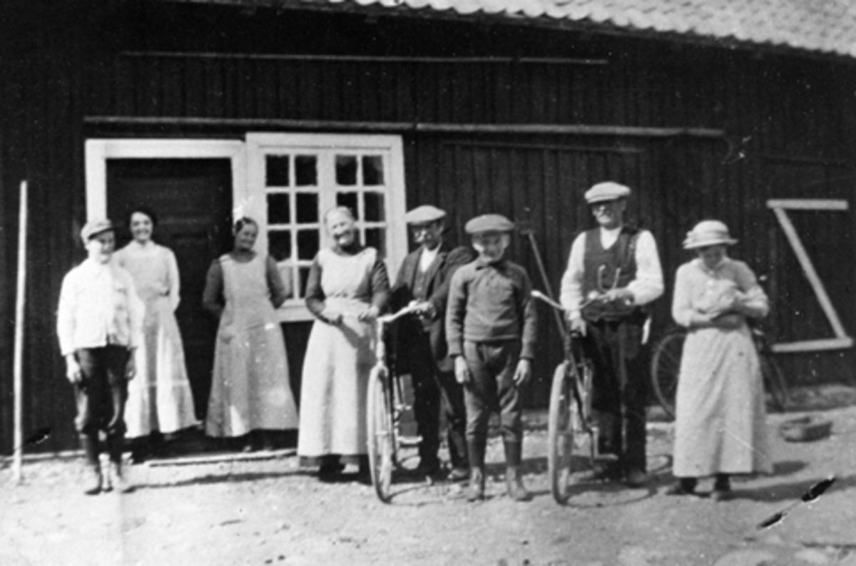 Anno Domkirkeodden, Voksne og barn foran uthus på Smedstuen nedre, Nes, Hedmark.