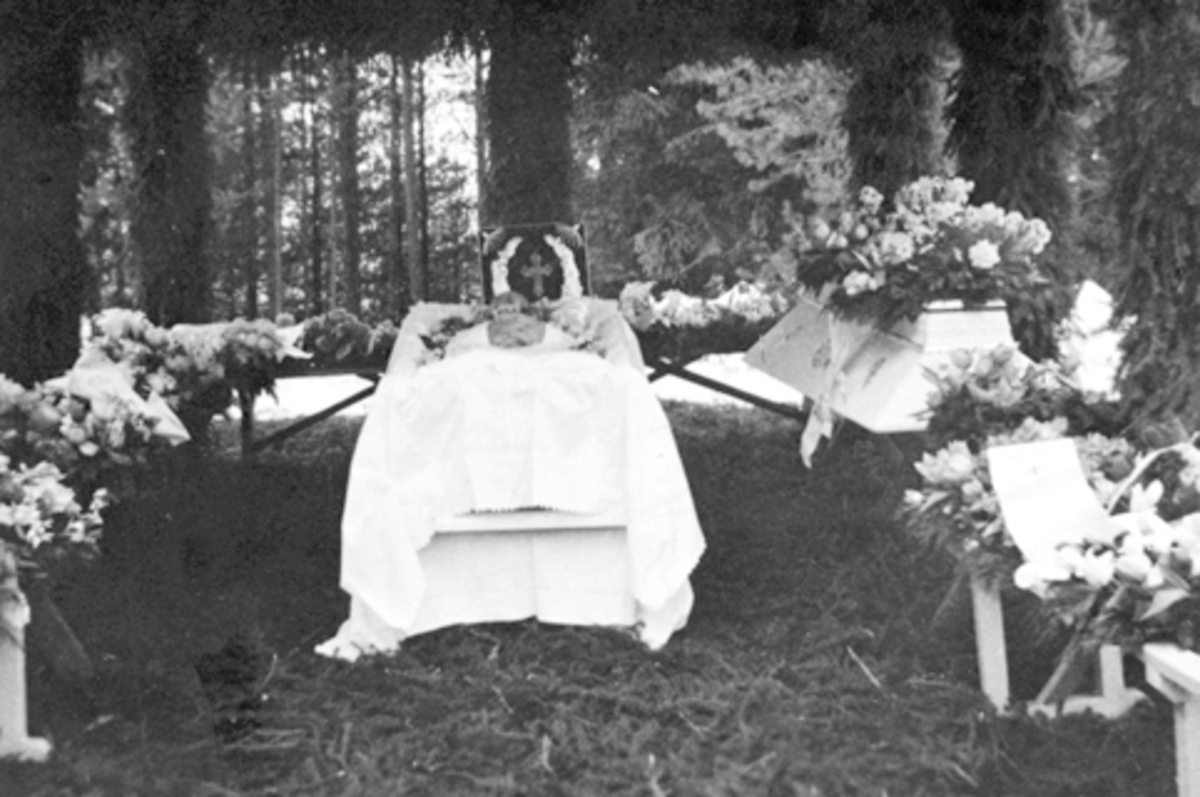 Anno Domkirkeodden, Begravelse etter Even Arnt lie (1865-1938), Smedstuen nedre, Nes, Hedmark. Barsal før lokket blir satt på kista. Pyntet med kranser og blomster, pute med sølvkors.