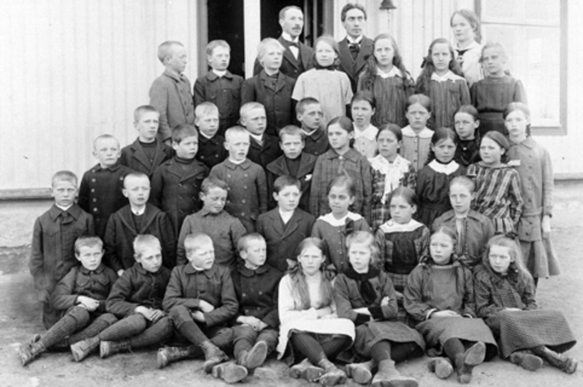 Anno Domkirkeodden, Elever og lærere ved Mørkved skole, Brumunddal. Bak er lærerne Nils Nyhus, Langdalen og frk. Ofigsbø. Nest bakerst er ukjent, Einar Jevanol, Georg Gudbrandsen, Anna Evensen, Borghild og Helga Enger (tvillinger), Liv Jevanol. Neste rad er ukjent, Håkon Gresby, Einar Viken, Asbjørn Veflen, Anna ?, He…