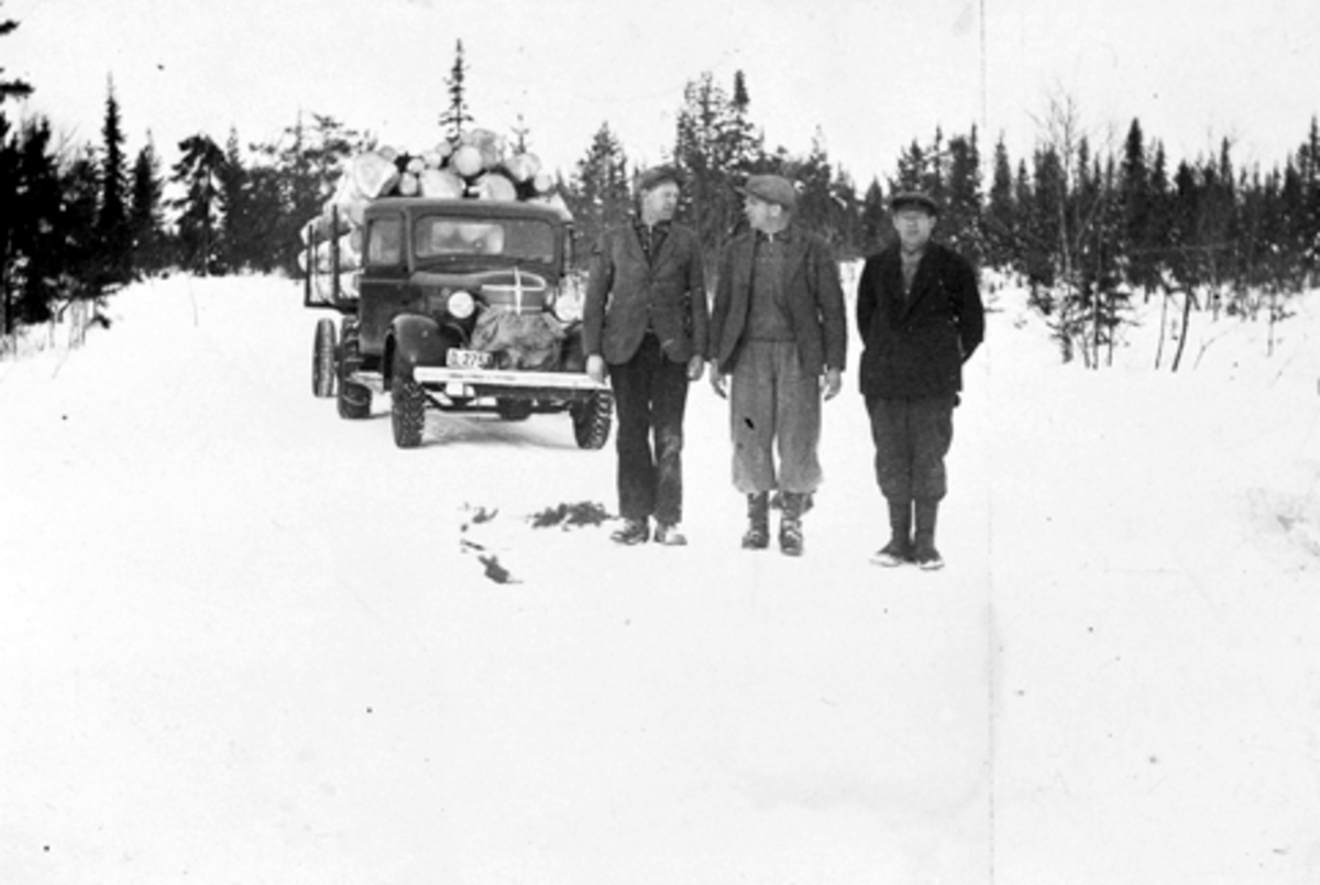 Anno Domkirkeodden, Tre skogsarbeider foran lastebil med tømmer. Fra venstre er Einar Jevanord, Alf Nordengen, Magne Solheim. Lastebilen er Chevrolet 1938 modell med norskbygd førerhus, trolig treseters. Tilhørende Ludvig Ødegarden, Basarud, Furnes Almenning.