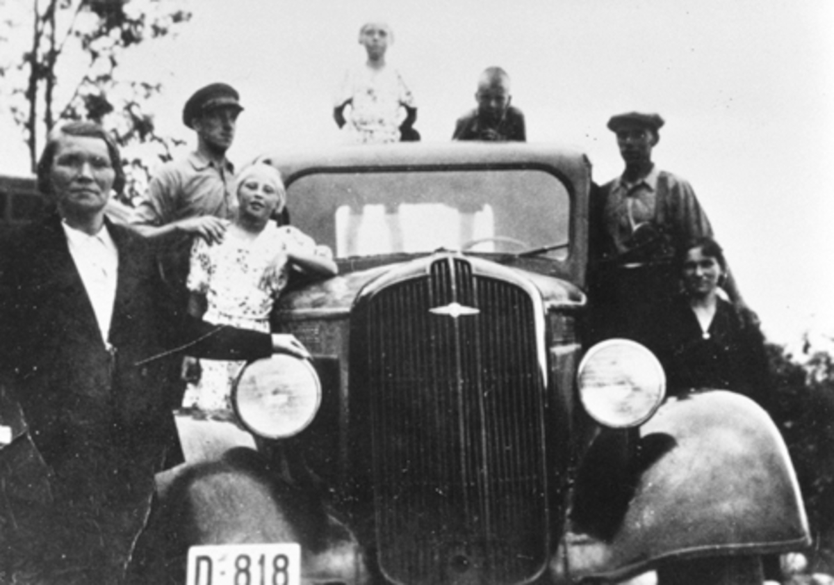 Anno Domkirkeodden, Martin Johansen og broren Alf kjøpte sin første bil i 1934, en gammel Ford som de eide sammen. I 1936 kjøpte de en ny Dodge som de kjørte melkeruta med. Her familien samlet rundt bilen, D-818. Fra venstre er Karen F.1897, Alf F.1910, Jenny og Reidun Flikkenhaug, Johan Martinsen F.1931, Martin F.190…