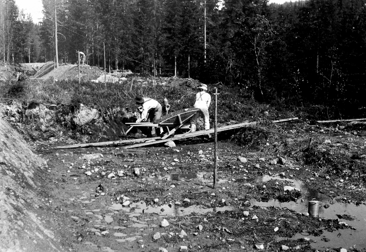 Anno Domkirkeodden, Utgraving av tilførselkanal til Moelv kraftstasjon, ble bygget for Moelv Cellulosefabrikk ca. 1907-1909. Kanalen var 1600 meter lang og kraftverket produserte ca. 800kw. Arbeidere med trillebår.