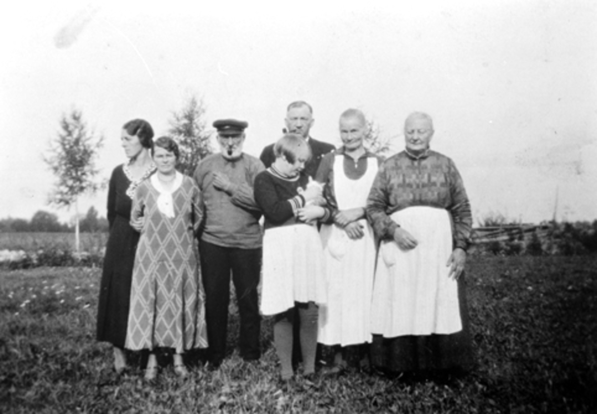 Anno Domkirkeodden, Småbruk, Rønningen, Helgøya, gruppe. Fra venstre : Marie Rønningen, Sofie Bjerke, Andreas Rønningen, Synnøve Bjerke med katt, Magnus Bjerke, Tilla Rønningen, Marie Andersdatter (ugift, syerske) som er søster til Andreas.