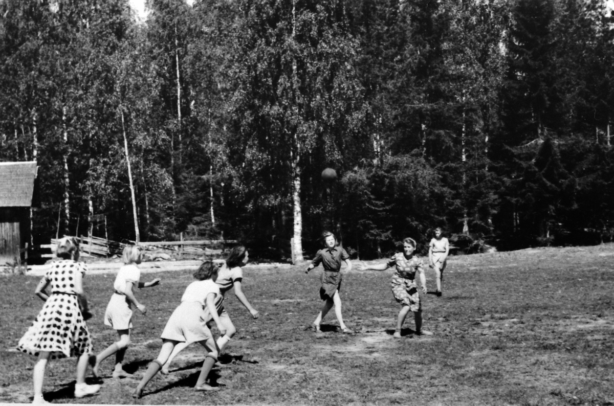 Anno Domkirkeodden, Aslasletta, Veldre, Ringsaker. Tilhørte Veldre turn fra 1904. Ble brukt mye til sportslige aktiviteter i ti-åra før og etter krigen. Bildet er tatt ca. 1945-46 og viser en ungdomsgjeng i ball-lek. De ble rekruttert av (AT (arbeidstjenesten) under krigen, og en del av dem ble igjen etter krigen.