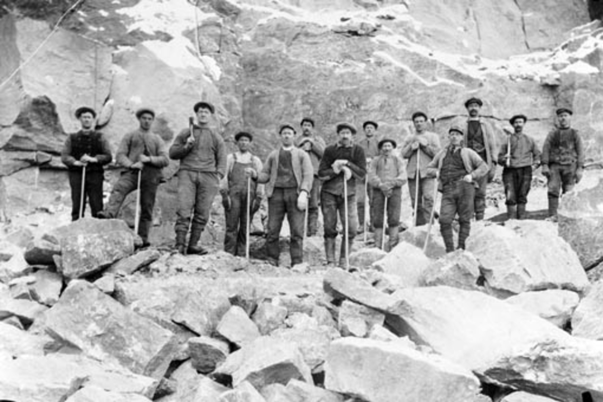 Anno Domkirkeodden, Arbeidere i steinbrudd på Hellerud, Furnes. Fra venstre er Mathias Iversen, Paul Ødegård, Hjalmar Brobakken, ukjent, Andreas Murstad, Hans Solhøi, Bjarne Fredriksen, Mekkel Grønstad, Ole Mikkelsen, Aksel Kristiansen, ukjent, Kristian Havik, ukjent, Albert Olsen,. Olsen og Solhøi var formenn i arbei…