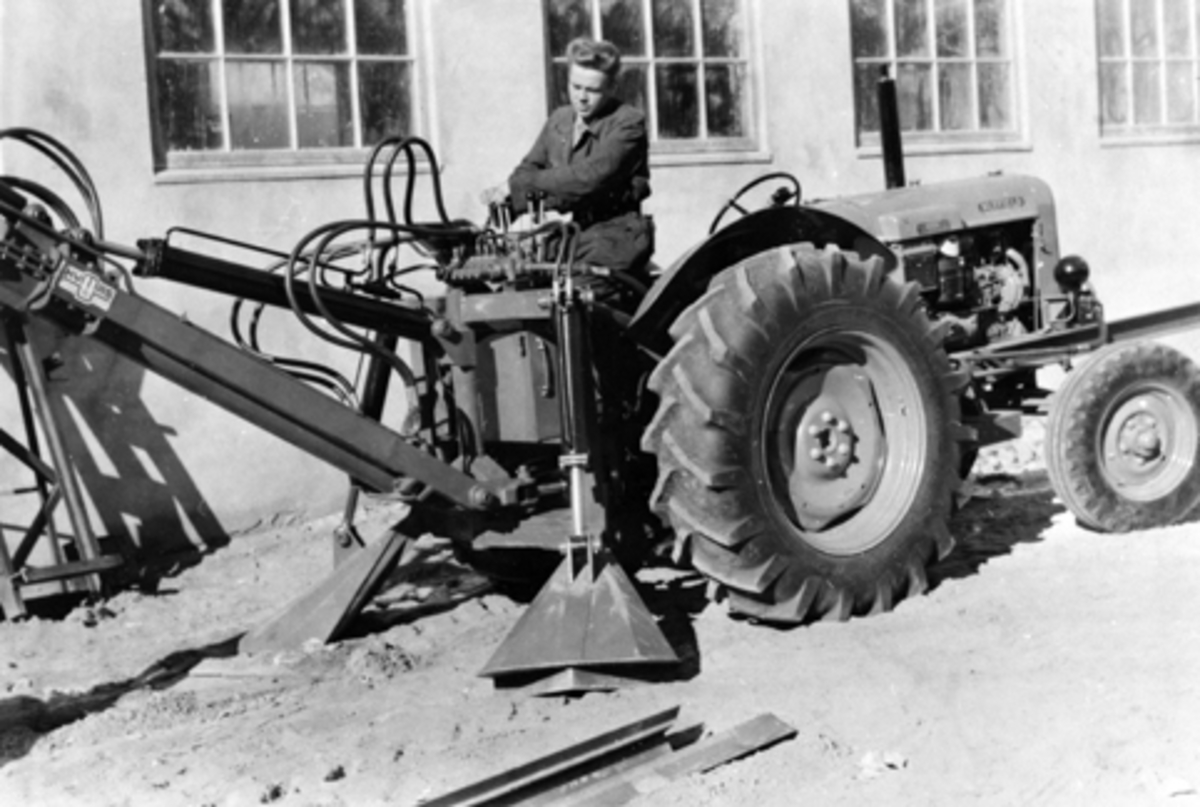 Anno Domkirkeodden, Traktor med gravemaskin produsert av Hymas A/S, Brumunddal. Ukjent mann på traktor.