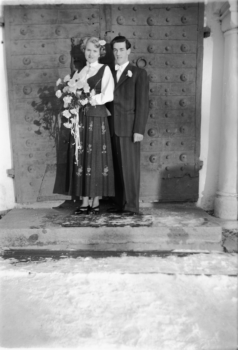 Håkon Prestkværn, Bergljot og Sverre Roseth, Moelv. Bryllup. Brudepar i bunad og dress på kirketrappa.