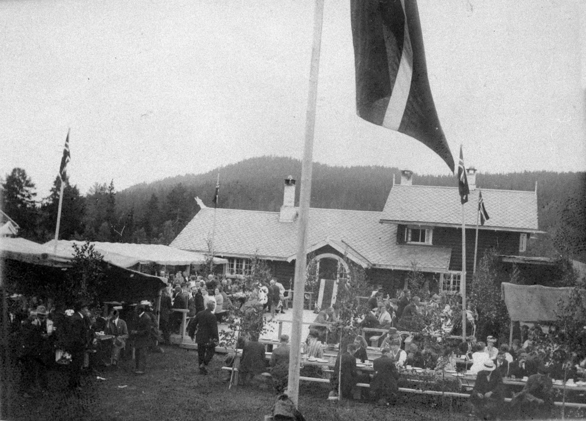 Normann Helger, EKSTERIØR: MALUNGEN, MYE FOLK VED LANGBORD, UTENDØRS. VALLSET,