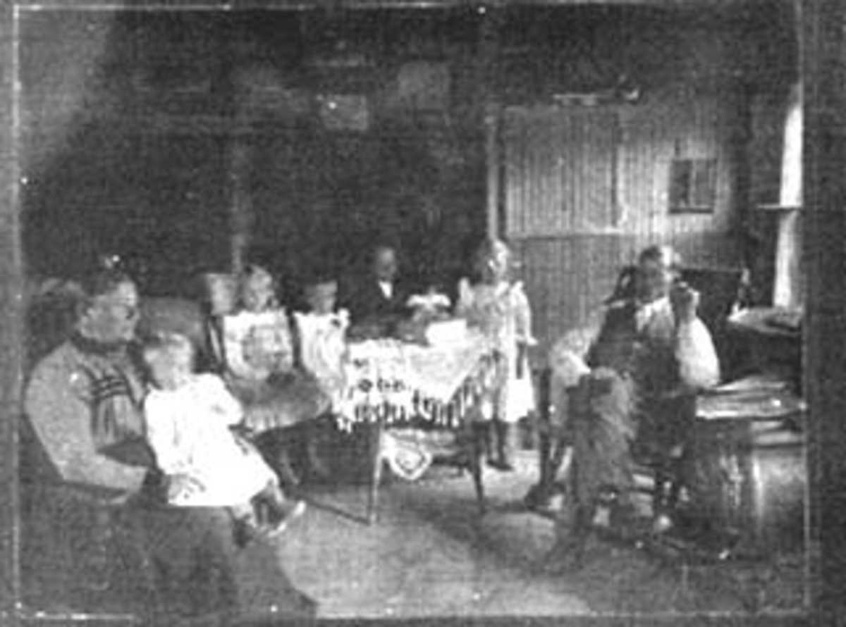 Normann Helger, INTERIØR: BOLIG, GRUPPE: 7, FAMILE, MOR, FAR, 5 BARN, BORD MED DUK, STOLER, OVN, BØKER, AVISER, BILDER, UKJENT FAMILIE, USA (STANGE).
