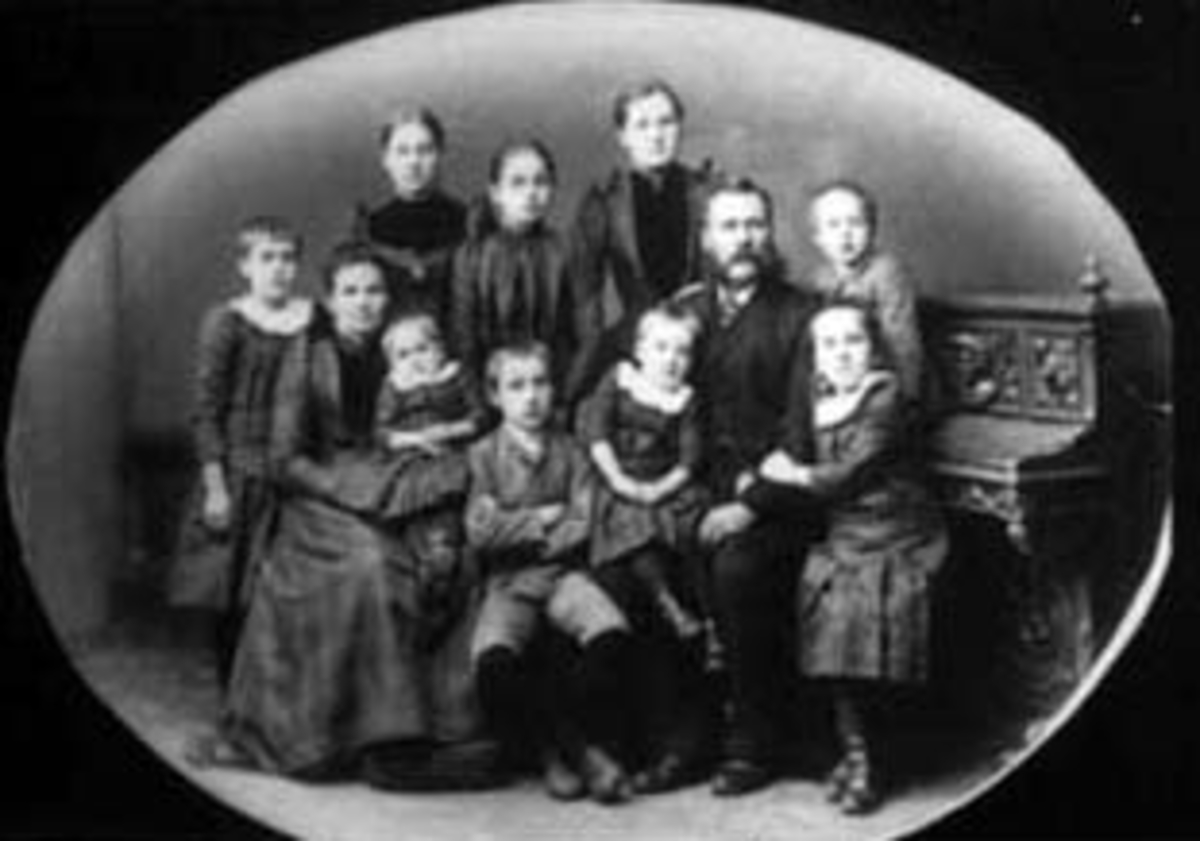 Anno Domkirkeodden, GRUPPE 11, FAMILIEN JERNBANESTASJONSMESTER JOHN JØRGENSEN MELBYE OG PERONELLE MELBYE, BAK FRA VENSTRE: EMMA, INGA OG JONETTE, FORAN: RAGNA, PETRONELLE MED SOFIE PÅ FANGET, JOHAN, JOHN MED MAGDA PÅ FANGET, HARALD OG MARIE.
