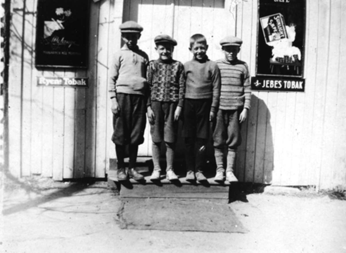 Anno Domkirkeodden, F. V. LARS LARSEN, EGIL STENDAHL, GEORG FJELD OG SVERRE STENDAHL, FORAN BUTIKKEN TIL STRAND JOHNSEN. TOBAKKSREKLAME, JEBSENS TOBAK OG RYENS TOBAK. CA 1930.