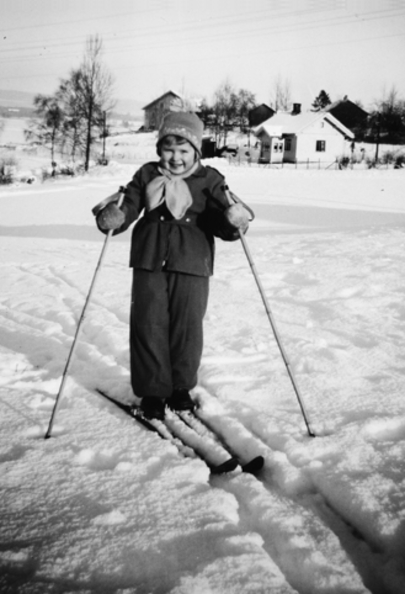 Anno Domkirkeodden, HEGGELUND I STANGE. VINTER. RAGNHILD ENGENE (HEGGELUND) PÅ SKI. I BAKGRUNNEN SEES HUSHAGEN, LILLEHUSHAGEN OG "STUA I SVINGEN" ALT ER NÅ REVET.