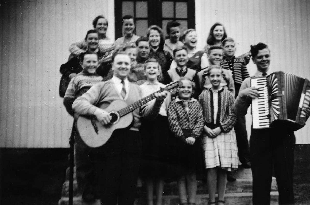 Ukjent, Ungdomsmusikken i Betel, Vallset ca. 1957. Sang og musikk. Foran med gitar Arne Gustavsen, med trekkspill Olav Gustavsen. Personer som er med på bildet: Ole Kristian Sjølie, Norunn Sjølie, Kari Høgaasen, Nell Edith Botten, Edith Østberg, Grete Botten, Sissel Ervik, Solfrid Nymoen, Sven Josef Ervik,…