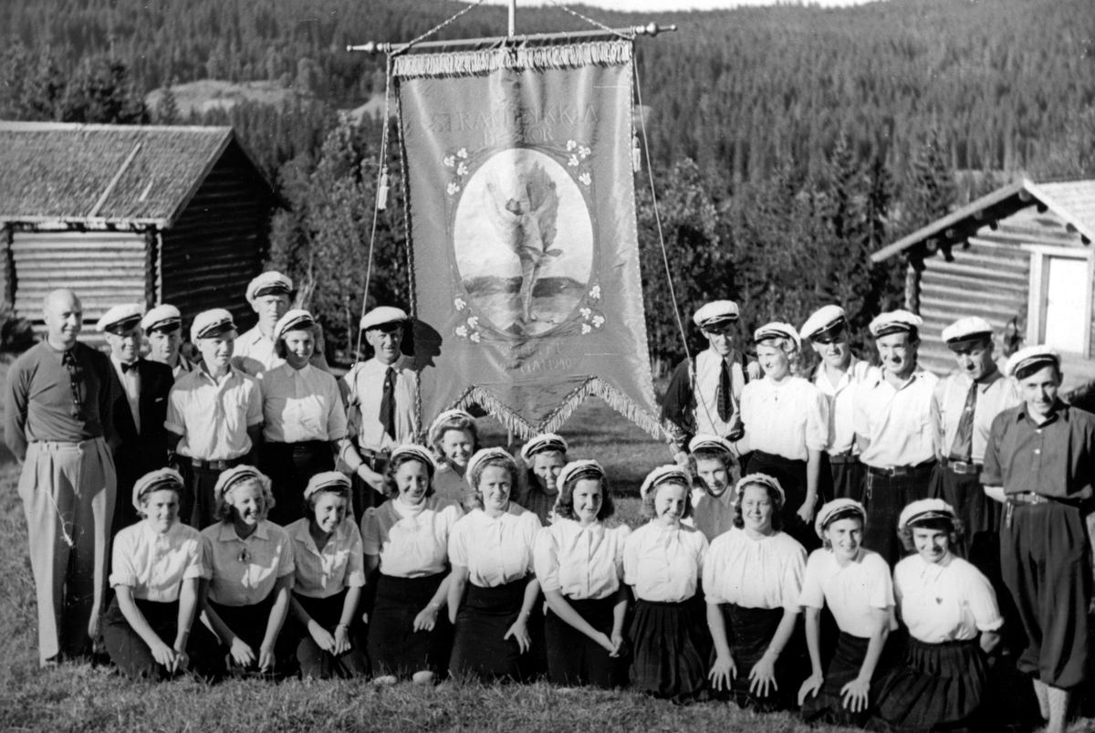 Ukjent, Det første Strandlykkja blanede kor. Sangkor. Fane. Foran f. v. Gudrun Romsaas., Karen Gulbrandsen, Ruth Westby, Åse Vangen, Dagny Henriksen, Synnøve Johansen, Eva Lien, Rannaug Finnstun, Gerd Kjernli, Åshild Kroksveen, og Gunvor Nordhagen. 2. rekke f. v. Dirigent Petter Dahl, Finn Kjernli, Simen L…