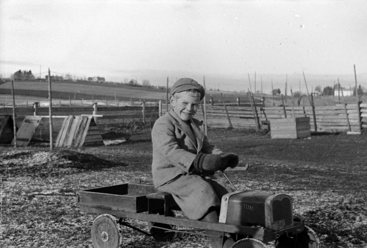 Adolf Skjegstad, ODD KJELL SKJEGSTAD, 6 ÅR, LEKEBIL, TRÅKKEBIL, BARNELEKE, UTHUS GARD, STANGE, OKTOBER 1941. FAREN A, SKJEGSTAD HADDE BILDET OVER SENGA SI DA HAN SATT PÅ GRINI UNDER KRIGEN, MEN DET BLE FORBUDT. HAN GJEMTE DET OG OPPBEVARTE DET ILLEGALT. SE ÅRBOKA " GAMMALT FRA STANGE OG ROMEDAL"2004 SIDE 22. .