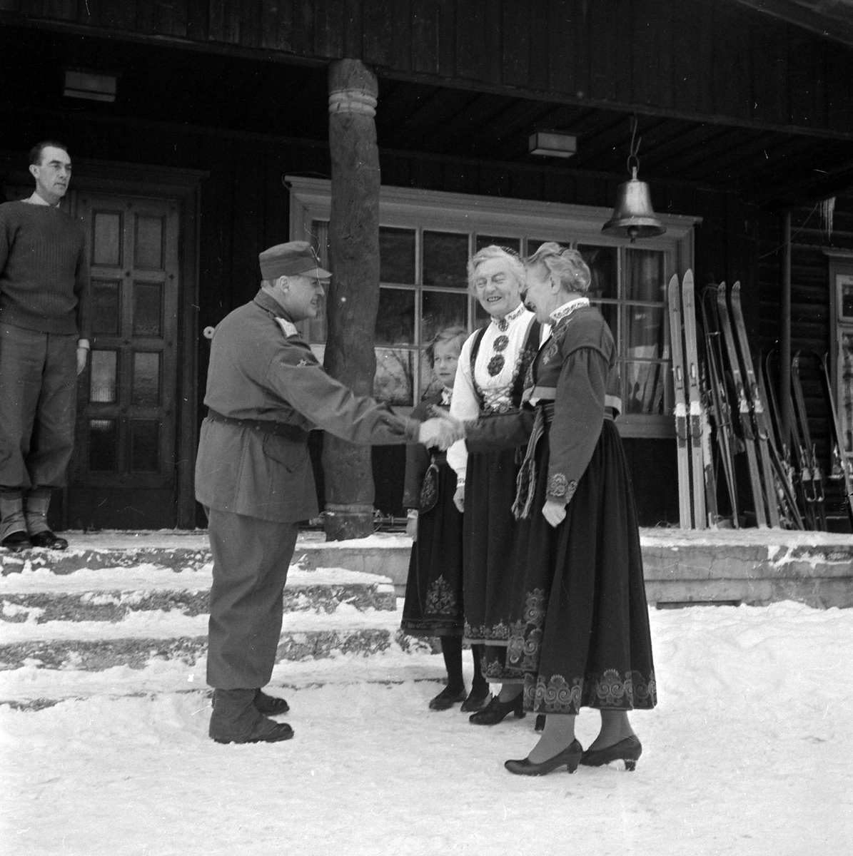 Adolf Skjegstad, KONG OLAV I MILITÆRUNIFORM HILSER PÅ TO KVINNER I BUNAD, FOLKEDRAKTER. UKJENT STED.
