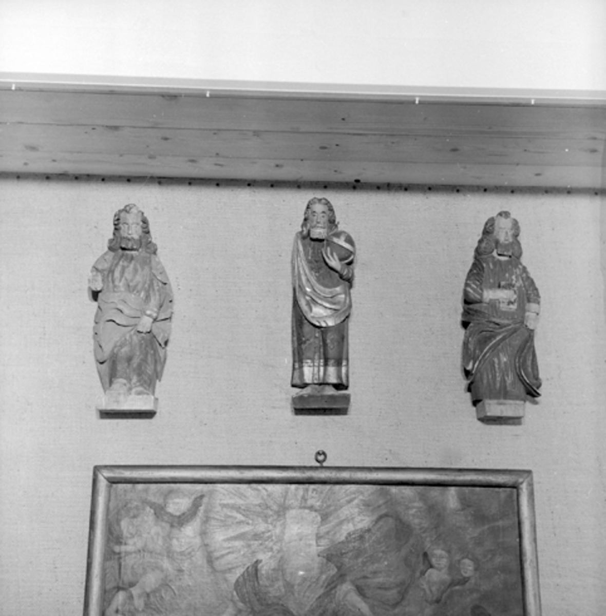 Anno Domkirkeodden, GJENST. KIRKEKUNST, 3 FIGURER, TOMTER KIRKE I VALLSET. T. v. en apostel? Hvit sokkel, svart hår, grønn kjortel og rødgul kappe, antagelig skåret av samme mester som DOK-3747 og 3749. I midten en salvator mundi, antagelig skåret av Johs. Skråstad, med grønn sokkel, jordkloden blågrønn med gull. Mørk…