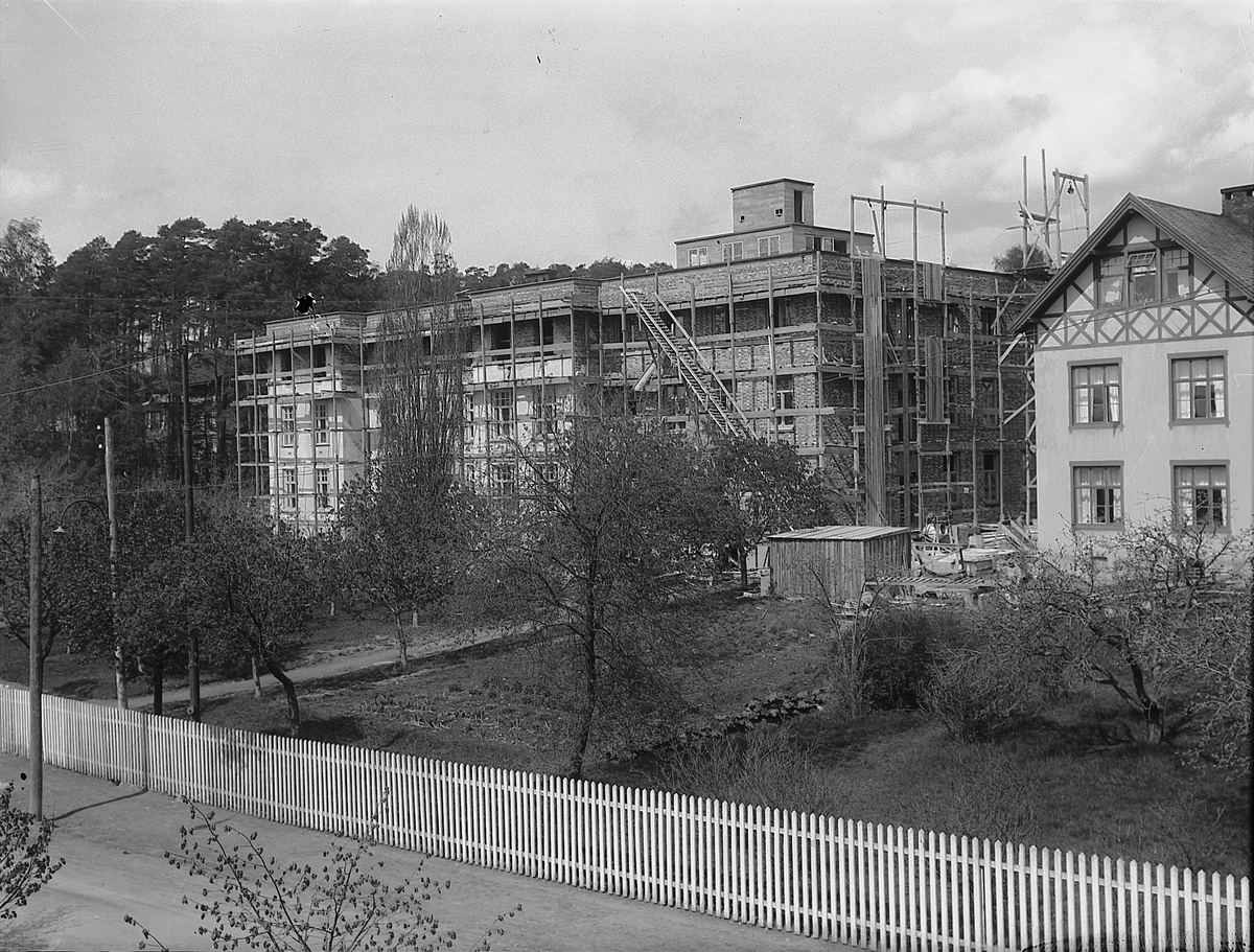 Christian Grundseth, Hamar sykehus under påbygging, det ble lagt til en etasje og oppført en ny fløy på østsiden av bygningen. Se HHB-00007 for original-bygget. Med stilaser sett fra sør. Det gamle sykehuset fra 1880 ses til høyre.