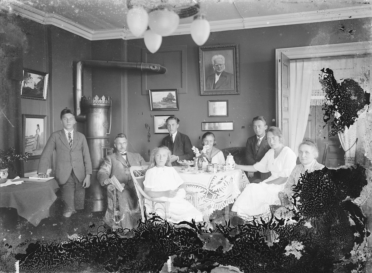 Oscar Løberg, Ukjent gruppe 8, familie i stueinteriør ved oppdekket bord, kaffe og kaker.