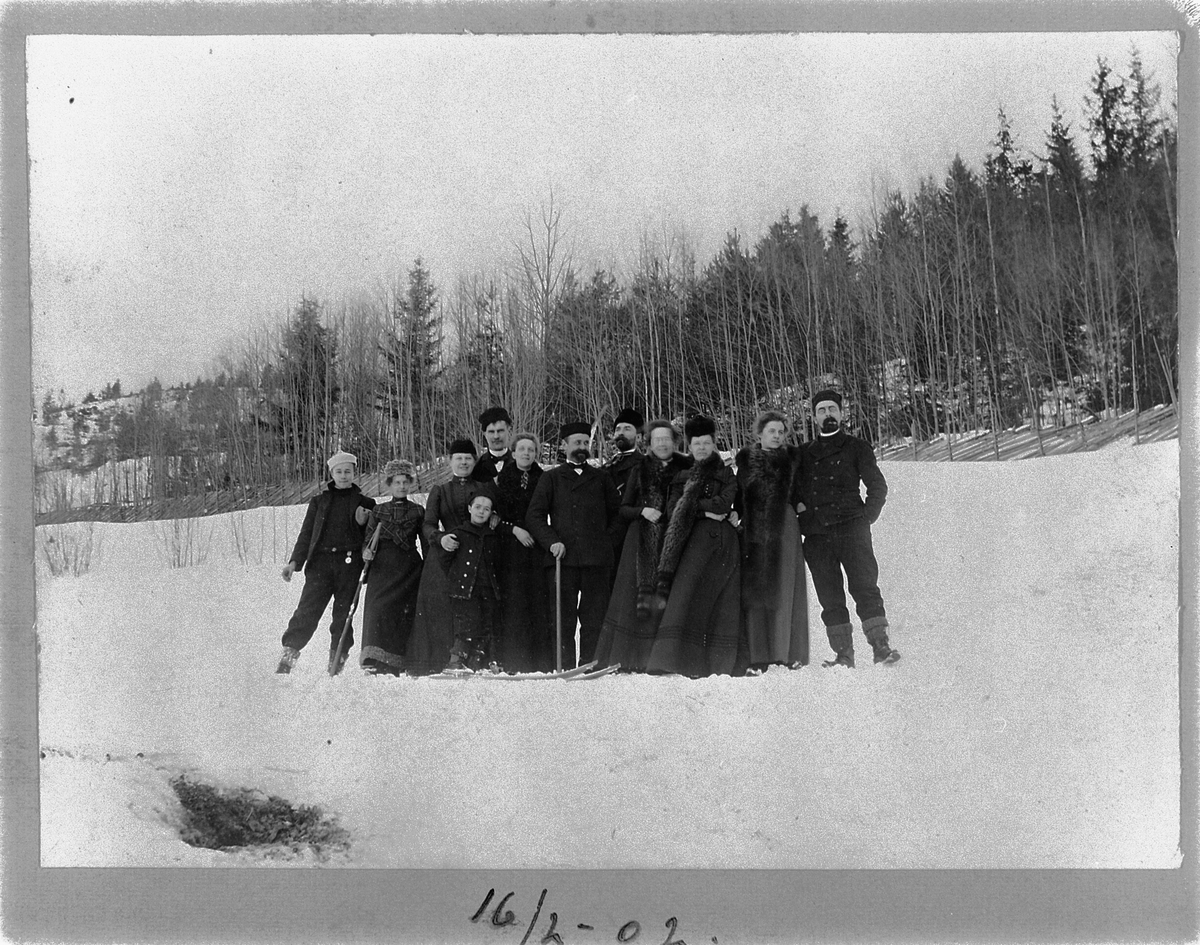 Johan Albert Steen, GRUPPE 12, UKJENTE MENN OG KVINNER, NOEN MED SKI. GRESSBYBAKKEN, FRAMBAKKEN I BRUMUNDDAL ? 16-2-1902.