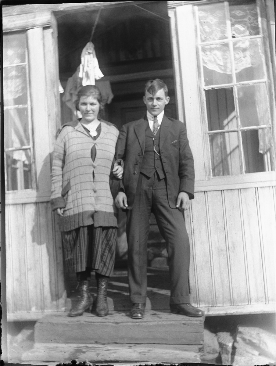 Ole M Martinsen, Ukjent kvinne og mann ved inngangen til et hus.